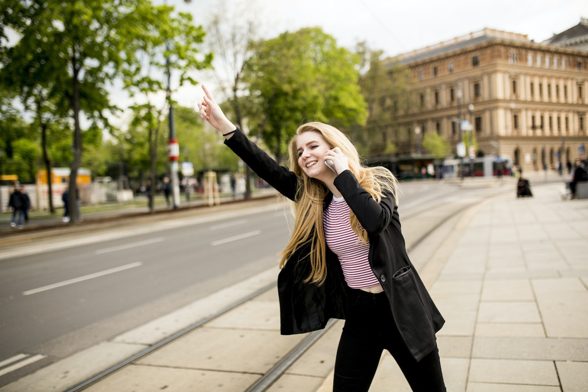 young-woman-hailing-a-taxi-on-the-street-in-the-city.jpg